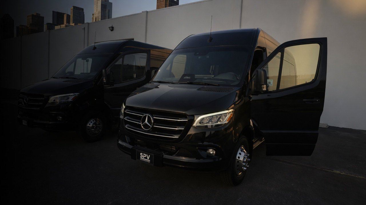 Two black Mercedes-Benz Sprinters on the Elmwood Park lot, doors open
