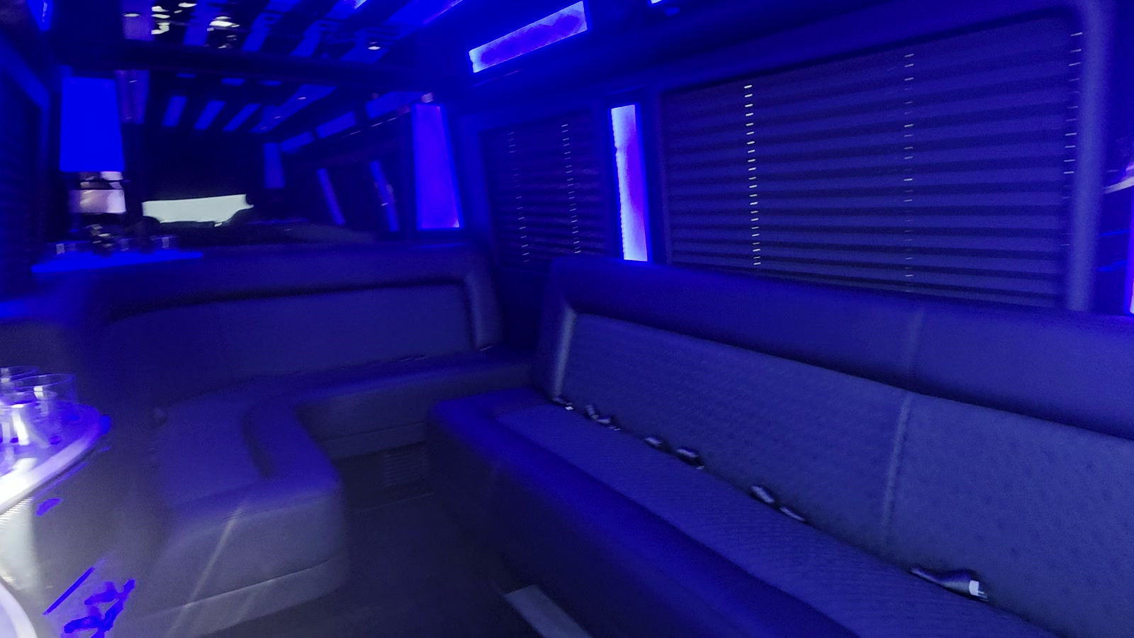 Extended Mercedes-Benz Sprinter lounge cabin with bench seating and blue ambient LED lighting